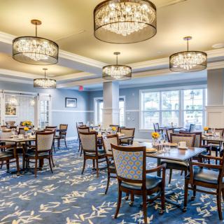 A beautifully decorated dining room with elegant chandeliers and neatly arranged tables.