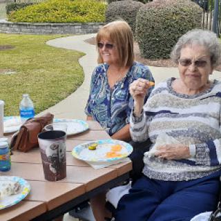 A lovely picnic gathering in the park with friends enjoying a meal together.