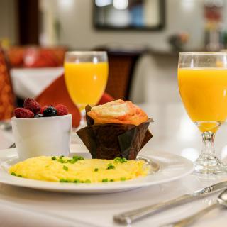 A delicious breakfast spread featuring an omelette, a muffin, a bowl of berries, and glasses of orange juice.