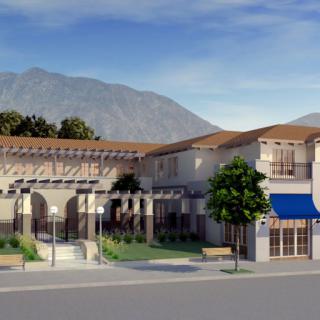 A modern building with a mountainous backdrop under a clear sky.
