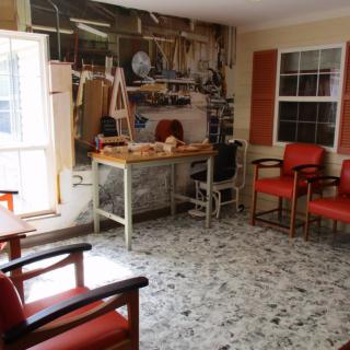 Vintage barbershop interior with red chairs and a workbench adorned with tools.