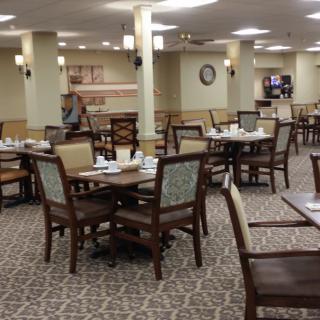 An empty dining room with neatly arranged tables and chairs, ready for service.