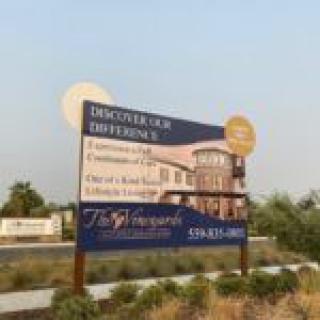 A promotional sign for The Vineyard, a senior living community.
