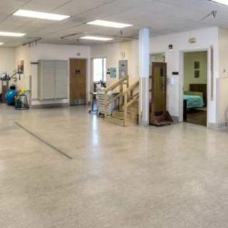 A spacious physical therapy and rehabilitation room with various equipment.