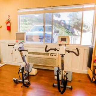 A bright workout room featuring two exercise bikes in front of a large window.