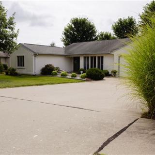 A suburban house with a large driveway and well-maintained front yard.