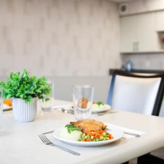 A beautifully set dining table with a delicious meal and decorative plant.
