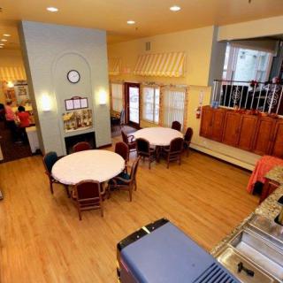 A cozy dining space with round tables and wooden flooring.
