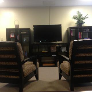 A cozy living room setup featuring two chairs facing a television.