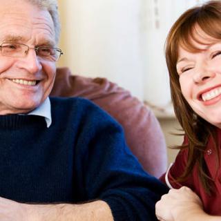 Two people smiling indoors, showing togetherness and happiness.