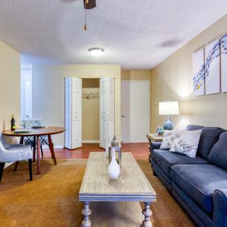 A cozy living room with a sofa, coffee table, and a small dining area.