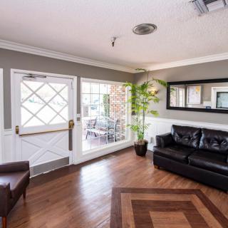 A cozy living room with a leather sofa, armchair, and wooden flooring.