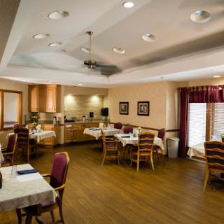A cozy and well-lit dining room with tables and chairs, designed for a pleasant dining experience.