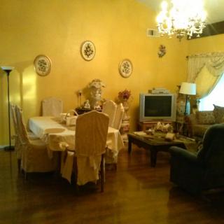 A cozy living and dining area with yellow walls and elegant furnishings.
