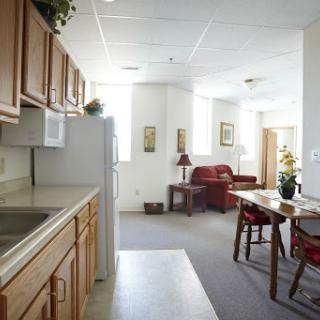 A spacious apartment featuring a kitchen area, dining space, and a cozy living room filled with natural light.