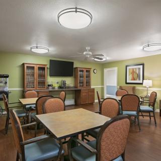 A modern dining area with tables, chairs, and a television.