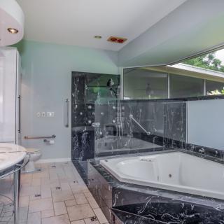 A luxurious bathroom featuring a marble bathtub and sleek modern design.