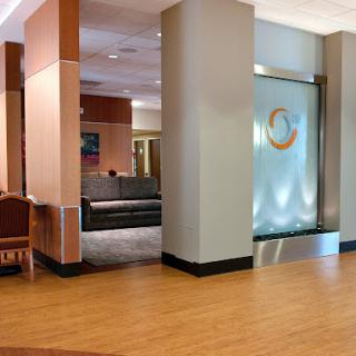 A modern hotel lobby featuring comfortable seating and a decorative water wall.