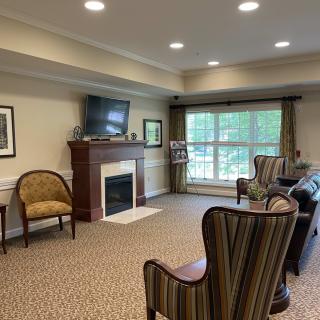 A cozy living room with a fireplace, television, and comfortable chairs.