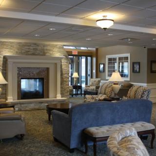 A cozy lobby area featuring a fireplace surrounded by comfortable sofas and ambient lighting.