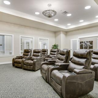 A luxurious home theater with comfortable recliner seating arranged in rows.