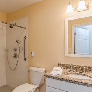 A clean and modern bathroom with a shower, toilet, and sink.
