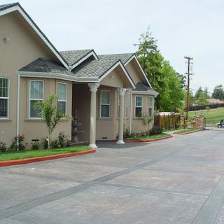 A suburban residential house with a driveway and landscaping.