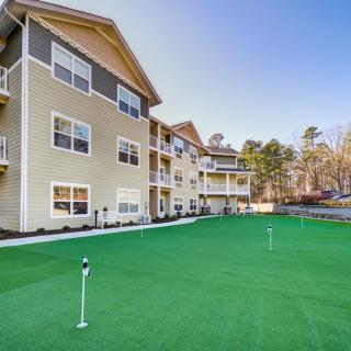 A modern apartment building with a golf putting green in the foreground.