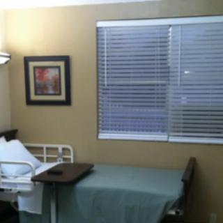 A quiet hospital room with a single bed and window blinds.