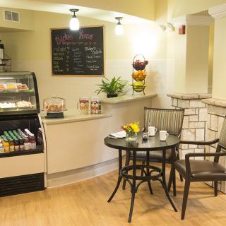 A cozy cafe interior with a small seating area and a menu board.