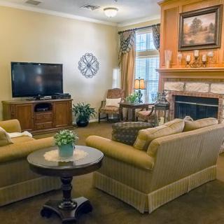 A cozy living room featuring a fireplace, sofas, and a television.