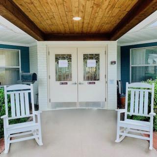 A welcoming porch entrance with two white rocking chairs.