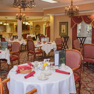 An elegant restaurant dining room with tables set for service.