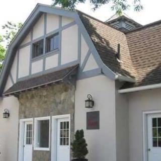 A Tudor-style residential building with a stone facade and steep roof.