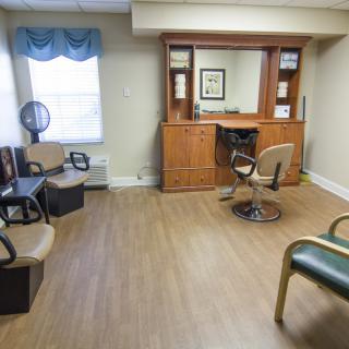 A cozy hair salon interior featuring a waiting area and styling station.