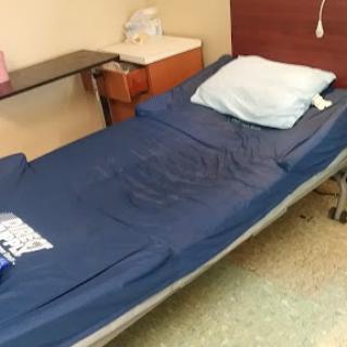 A hospital bed prepared for a patient, showcasing a clean and organized medical environment.