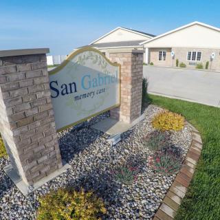A view of the San Gabriel housing community entrance sign with well-maintained landscaping and suburban homes in the background.