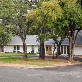 A suburban house surrounded by trees with a driveway.