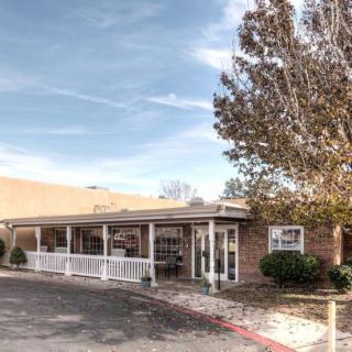 A building exterior with a covered entrance and landscaped surroundings.