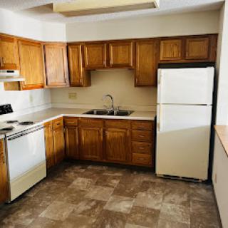 A spacious kitchen featuring wooden cabinets and essential appliances.