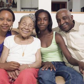 A joyful multigenerational family sitting together at home.