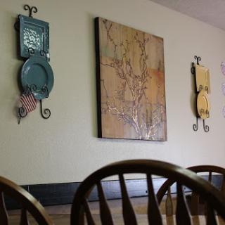 A cozy dining area featuring decorative wall art and wooden chairs.