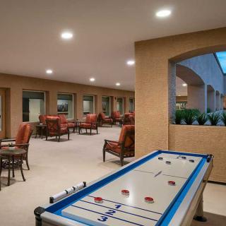 A spacious indoor recreation area featuring a shuffleboard table and comfortable seating.