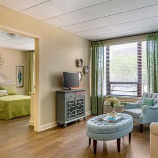 A modern apartment living room featuring comfortable seating and large windows.