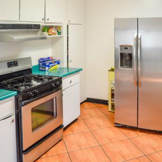 A modern kitchen with stainless steel appliances and tiled flooring.