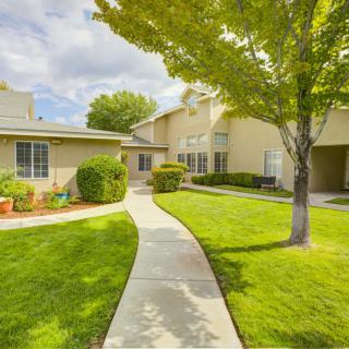 A charming residential home with a well-manicured lawn and a winding pathway leading to the entrance.