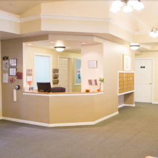 A spacious and well-lit reception area with a desk and seating.