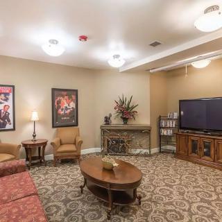 A cozy living room with a television, comfortable seating, and elegant decor.