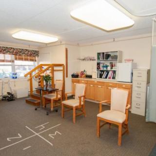 A well-lit office space with chairs, a desk, and shelving.
