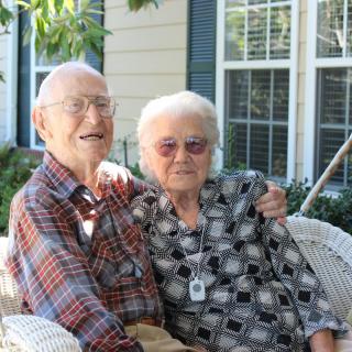 An elderly couple enjoying a moment together outside.